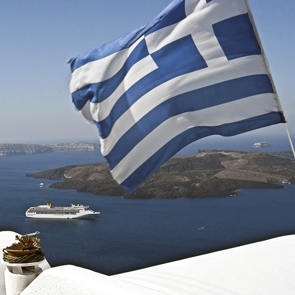 Greek flag and the sea, Santorini DEUS TRAVEL